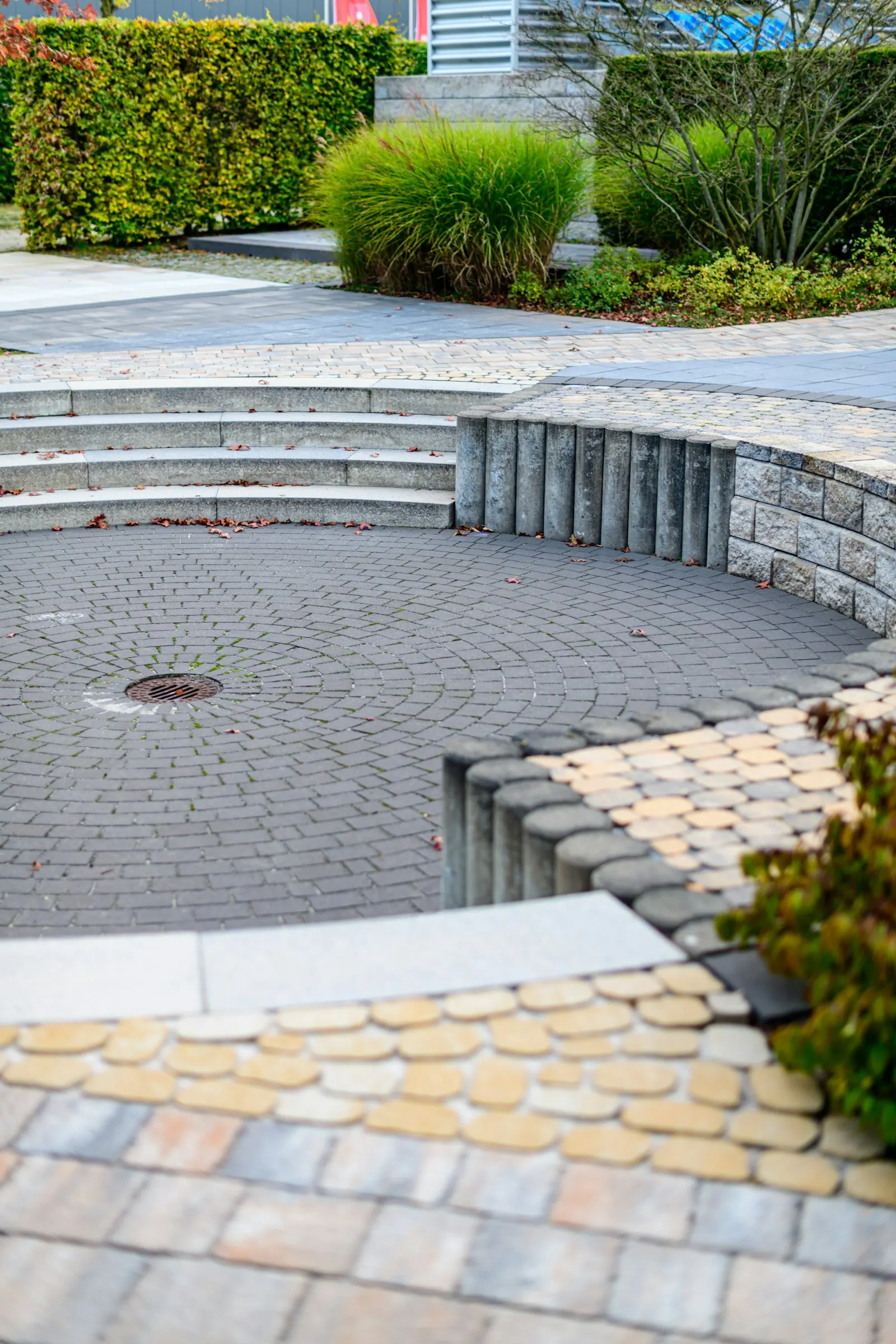 Curved paver patio with a small seating area surrounded by native plantings.